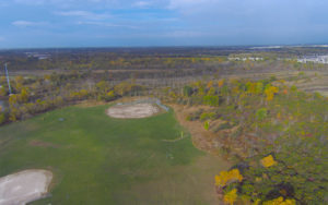 Aerial view of baseball diamonds and woods.