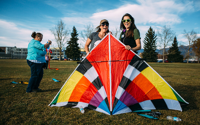 Two people holding large kite outside