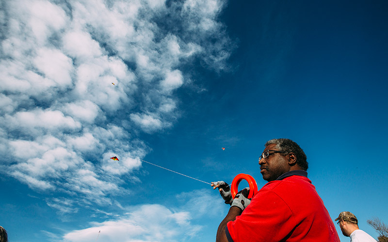 View of man flying kite (multiple kites in the air)
