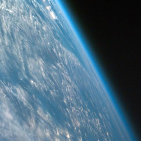 Picture of the Earth from space where the hazy blue ring of the atmosphere is visible.