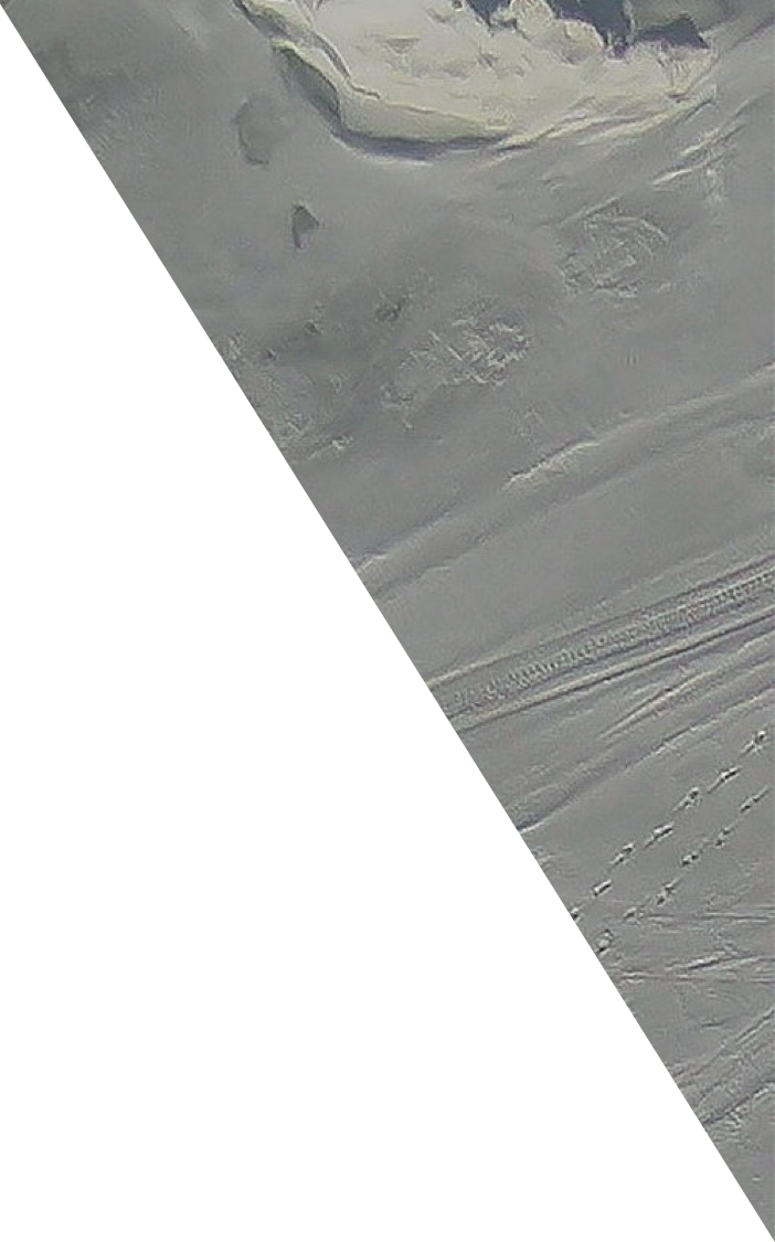Aerial image of sea ice with tracks and mounds of snow