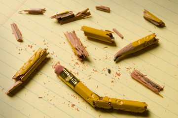 Broken pencils on a pad of paper.